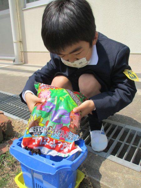 小学部1年の児童が鉢に土を入れている写真