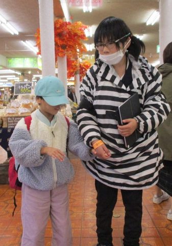 児童二人が手を繋いでお店の中で写真に映る様子。